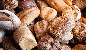 A pile of different types of bread loaves.